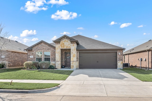 view of front of house with central AC, a front yard, driveway, stone siding, and an attached garage