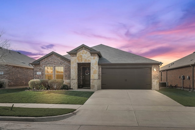 view of front of property with stone siding, concrete driveway, a front yard, a garage, and brick siding