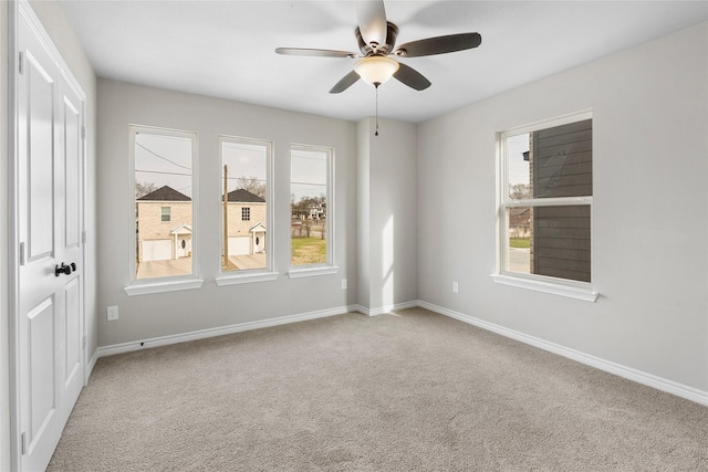 spare room with carpet floors, ceiling fan, and baseboards