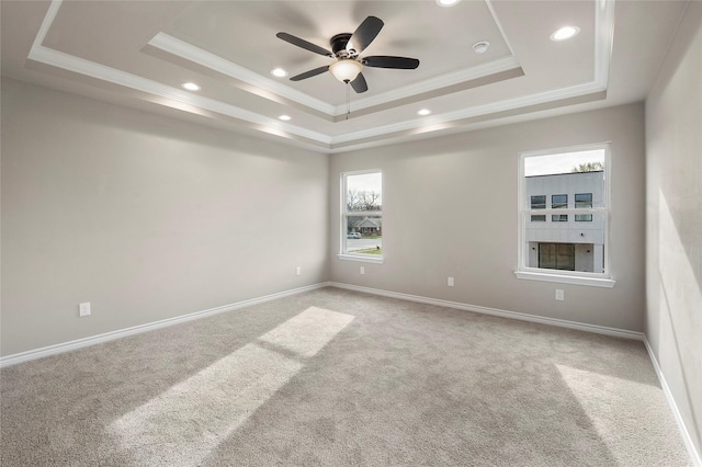 empty room featuring crown molding, recessed lighting, a raised ceiling, carpet flooring, and baseboards