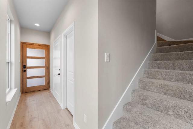 staircase with wood finished floors and recessed lighting