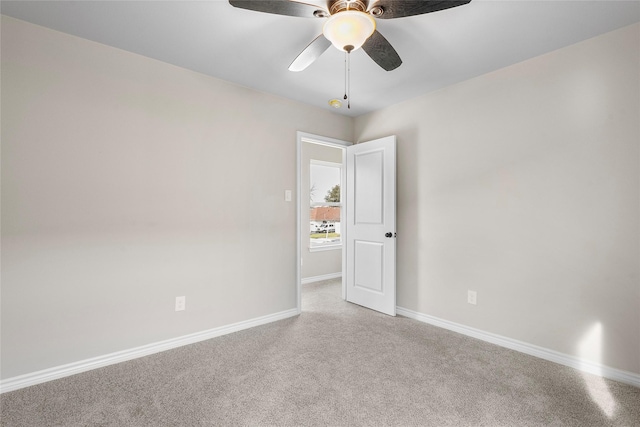 unfurnished room with a ceiling fan, baseboards, and carpet flooring