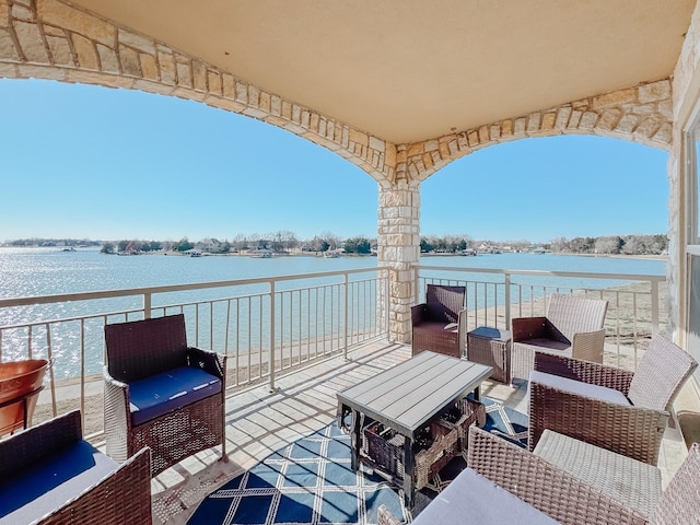 view of patio / terrace with a water view and a balcony