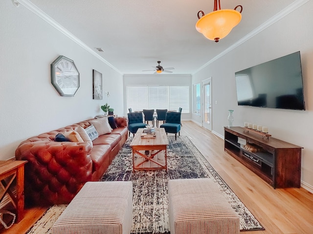 living room featuring ceiling fan, baseboards, wood finished floors, and crown molding