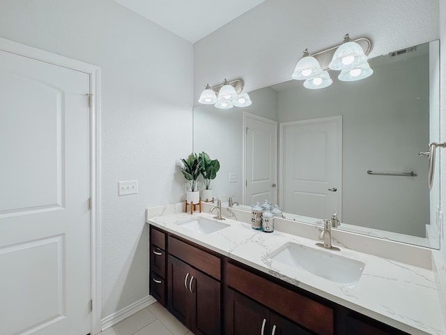 bathroom featuring visible vents, a sink, baseboards, and double vanity