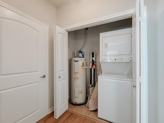 laundry room with water heater, laundry area, stacked washing maching and dryer, and light wood-style flooring