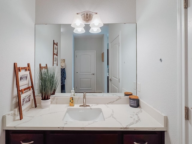 bathroom with a chandelier and vanity