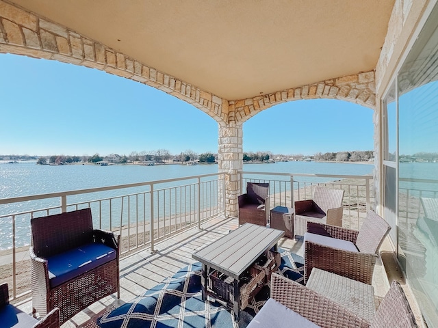 view of patio with a water view and a balcony