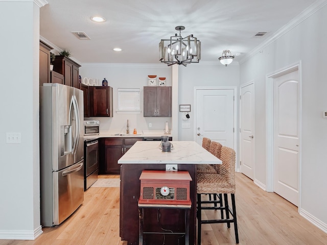 kitchen featuring a sink, stainless steel appliances, a kitchen island, and visible vents