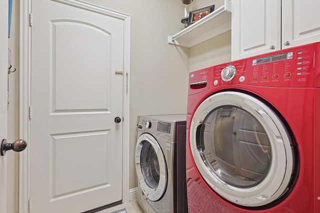 clothes washing area featuring cabinet space and independent washer and dryer