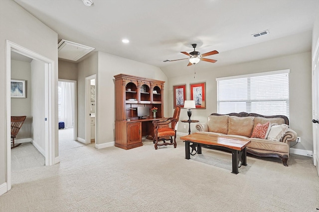 living area with lofted ceiling, light colored carpet, attic access, ceiling fan, and baseboards