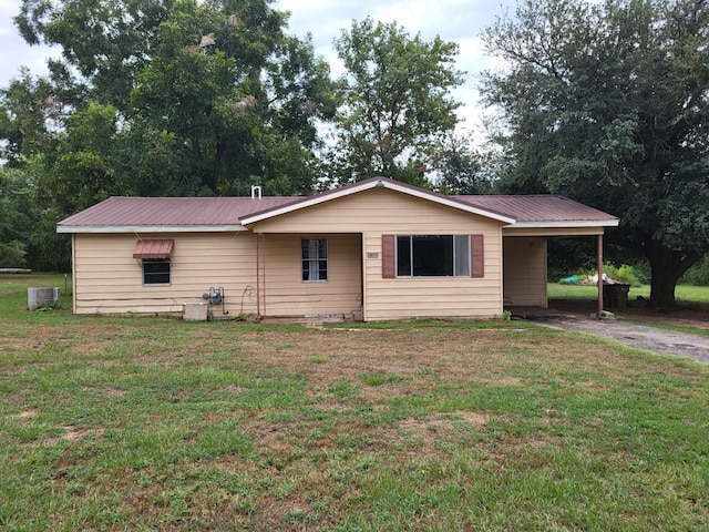 ranch-style house featuring driveway, metal roof, an attached carport, cooling unit, and a front yard