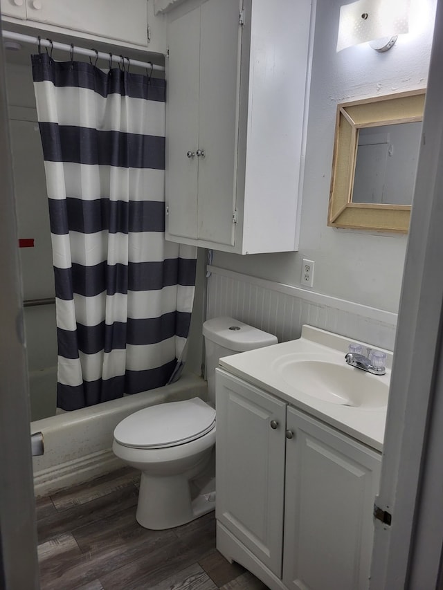 full bathroom featuring shower / bath combo with shower curtain, vanity, toilet, and wood finished floors