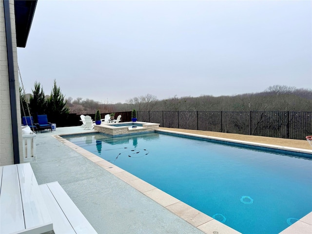 view of swimming pool featuring a patio, a fenced backyard, and a pool with connected hot tub