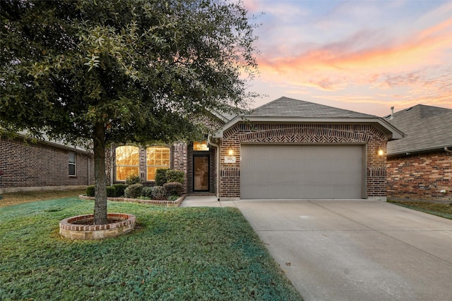 single story home with driveway, brick siding, a lawn, and an attached garage