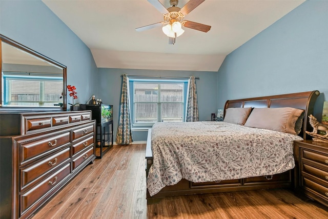 bedroom with lofted ceiling, light wood-style flooring, baseboards, and ceiling fan