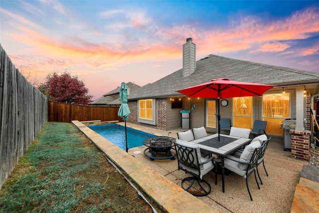 view of pool with a fenced in pool, a patio area, a grill, a fenced backyard, and a fire pit