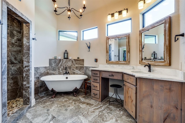 bathroom featuring tile walls, wainscoting, vanity, a freestanding tub, and tiled shower