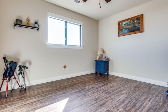 interior space featuring a ceiling fan, baseboards, visible vents, and wood finished floors