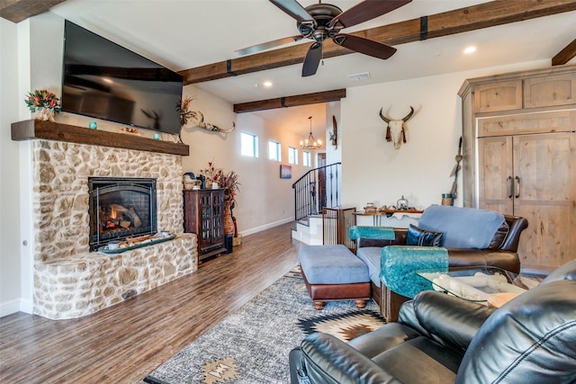 living area with beam ceiling, dark wood-type flooring, a fireplace, and visible vents