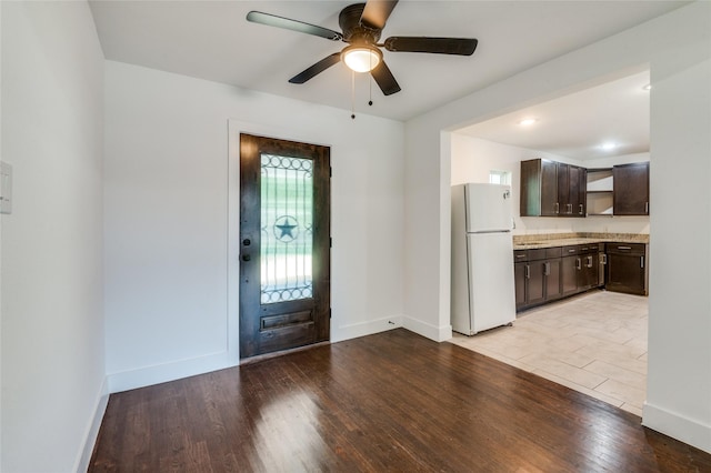 entryway featuring baseboards, a ceiling fan, and light wood-style floors