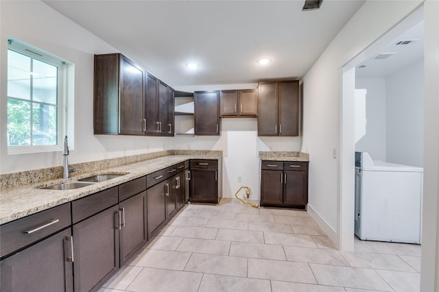 kitchen featuring dark brown cabinetry, washer / clothes dryer, and a sink