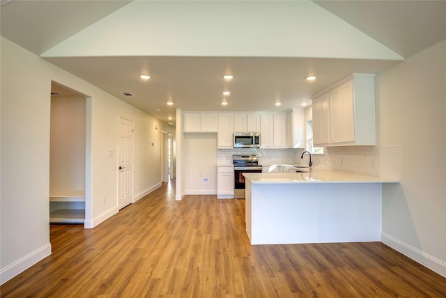 kitchen with a sink, appliances with stainless steel finishes, white cabinets, and light countertops