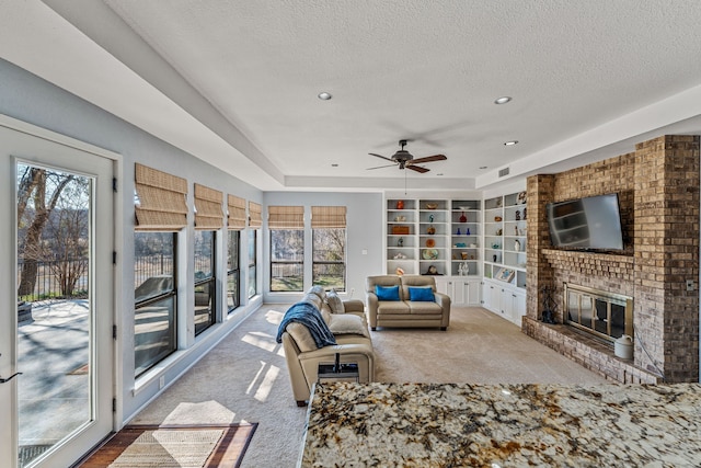 interior space with a brick fireplace, visible vents, and a ceiling fan