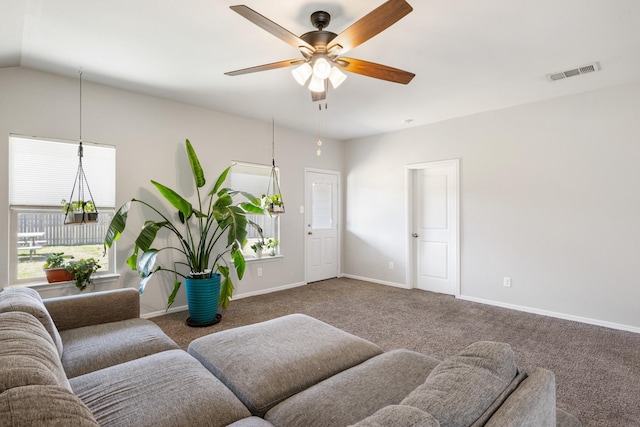 living room with carpet floors, lofted ceiling, visible vents, a ceiling fan, and baseboards