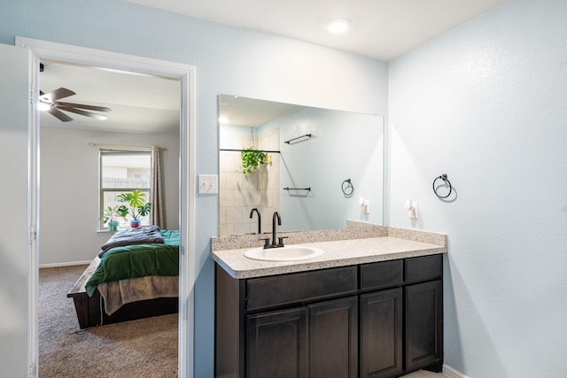 ensuite bathroom featuring ensuite bath, baseboards, a ceiling fan, and vanity