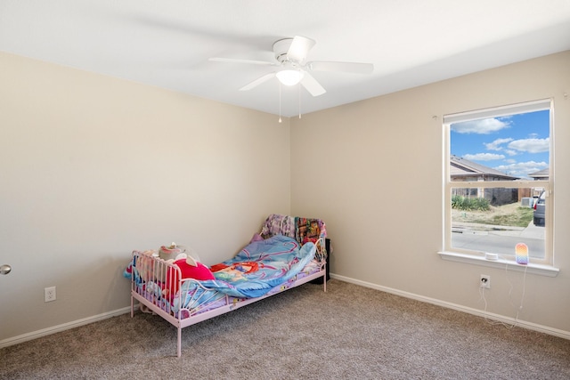 carpeted bedroom with ceiling fan and baseboards