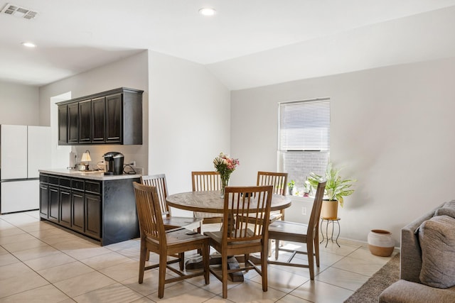 dining space with light tile patterned floors, lofted ceiling, recessed lighting, visible vents, and baseboards