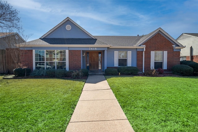 view of front of house featuring a front lawn, a shingled roof, and brick siding