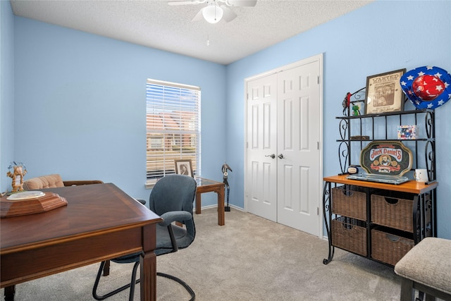 office space with a textured ceiling, carpet flooring, and a ceiling fan