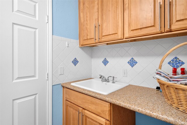 kitchen featuring light stone counters and a sink