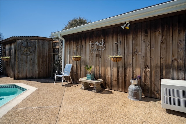 view of patio with fence and heating unit