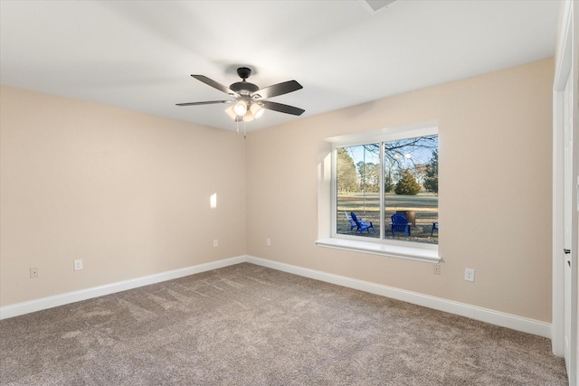 unfurnished room with carpet flooring, a ceiling fan, and baseboards