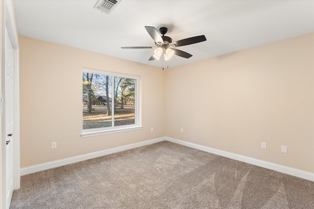 carpeted spare room with baseboards, visible vents, and ceiling fan