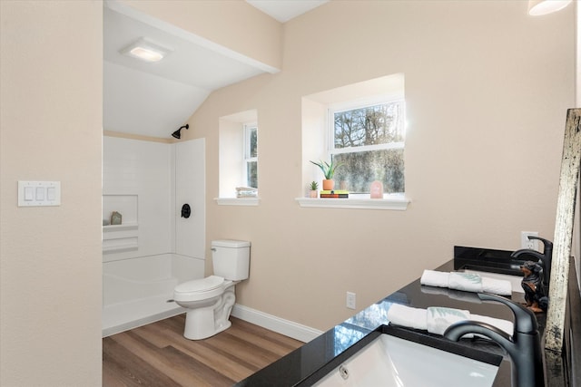 bathroom with baseboards, toilet, lofted ceiling, wood finished floors, and walk in shower