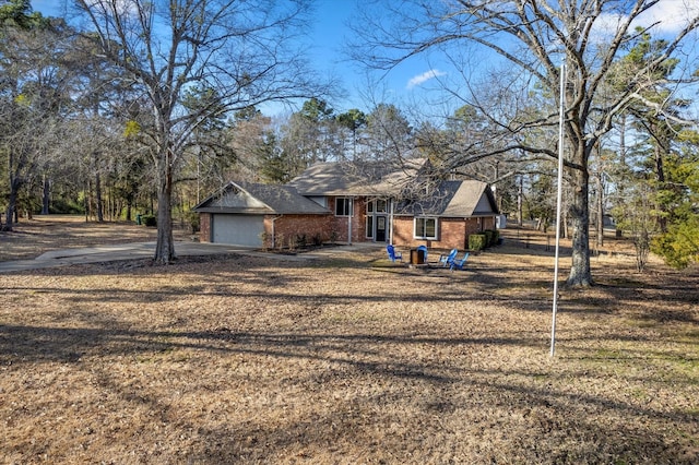 view of front of home featuring a garage, brick siding, driveway, and a front lawn