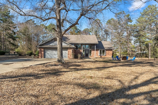 view of front of property featuring driveway, an attached garage, and brick siding