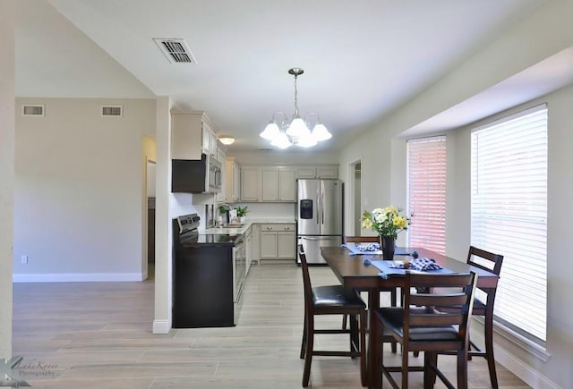 kitchen featuring visible vents, stainless steel appliances, and pendant lighting