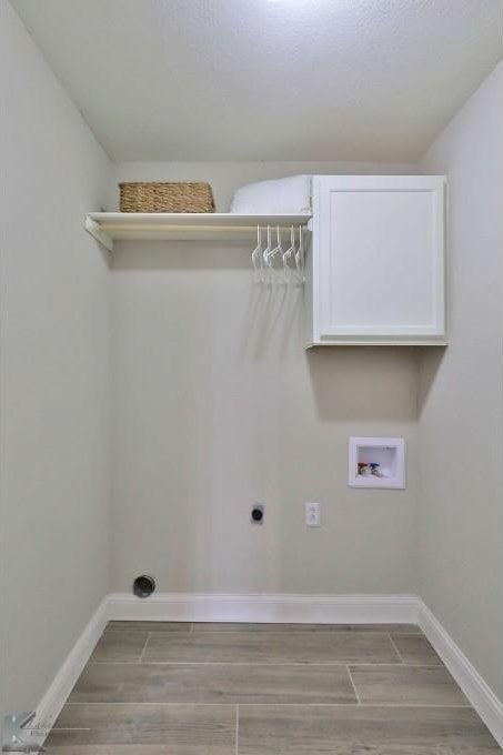 clothes washing area featuring washer hookup, electric dryer hookup, baseboards, and wood tiled floor