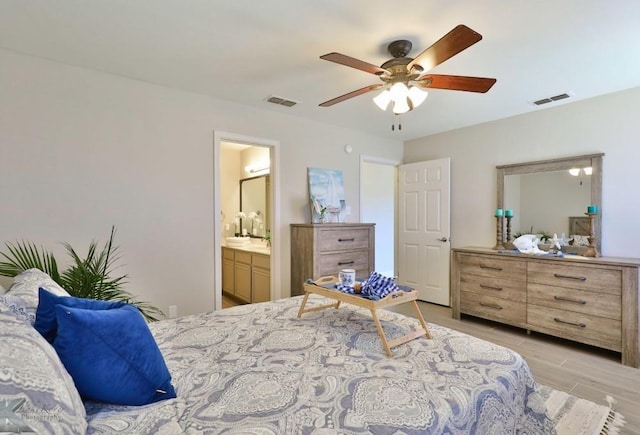 bedroom featuring visible vents, connected bathroom, light wood finished floors, and ceiling fan