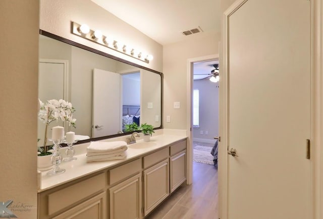 ensuite bathroom featuring visible vents, ensuite bathroom, ceiling fan, vanity, and wood finished floors