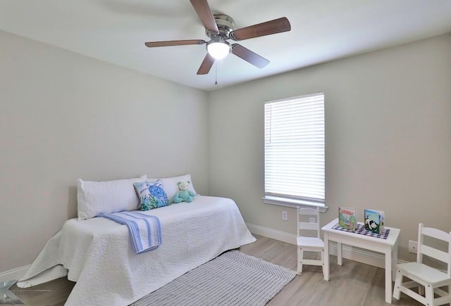 bedroom with light wood-style floors, baseboards, and a ceiling fan