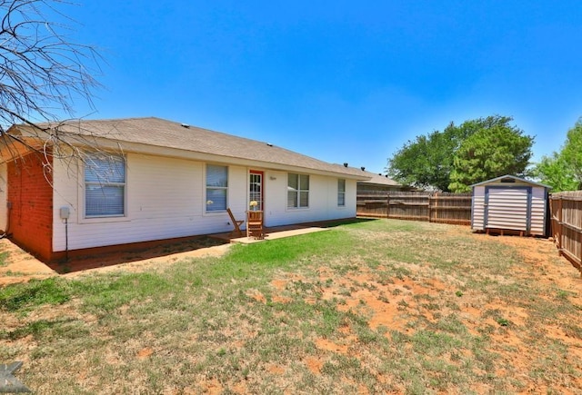 back of property featuring an outbuilding, a storage unit, a lawn, entry steps, and a fenced backyard