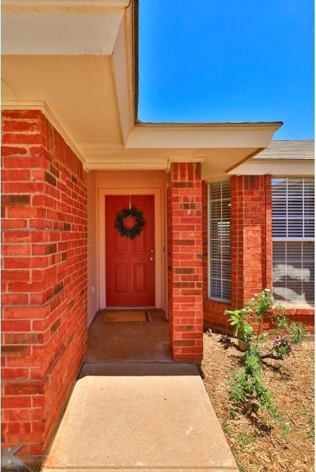 property entrance featuring brick siding