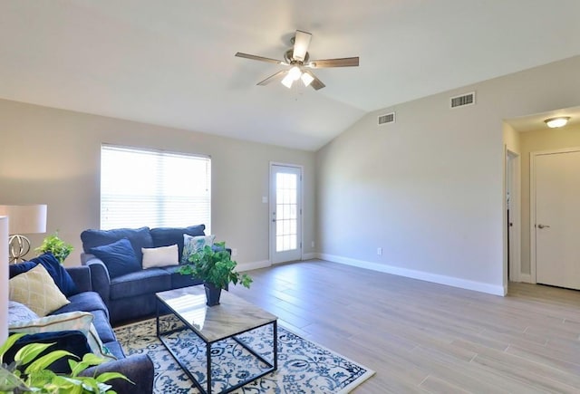 living room featuring visible vents, vaulted ceiling, and light wood-style flooring