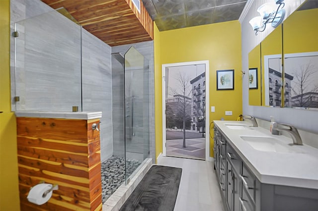 bathroom with double vanity, a stall shower, and a sink